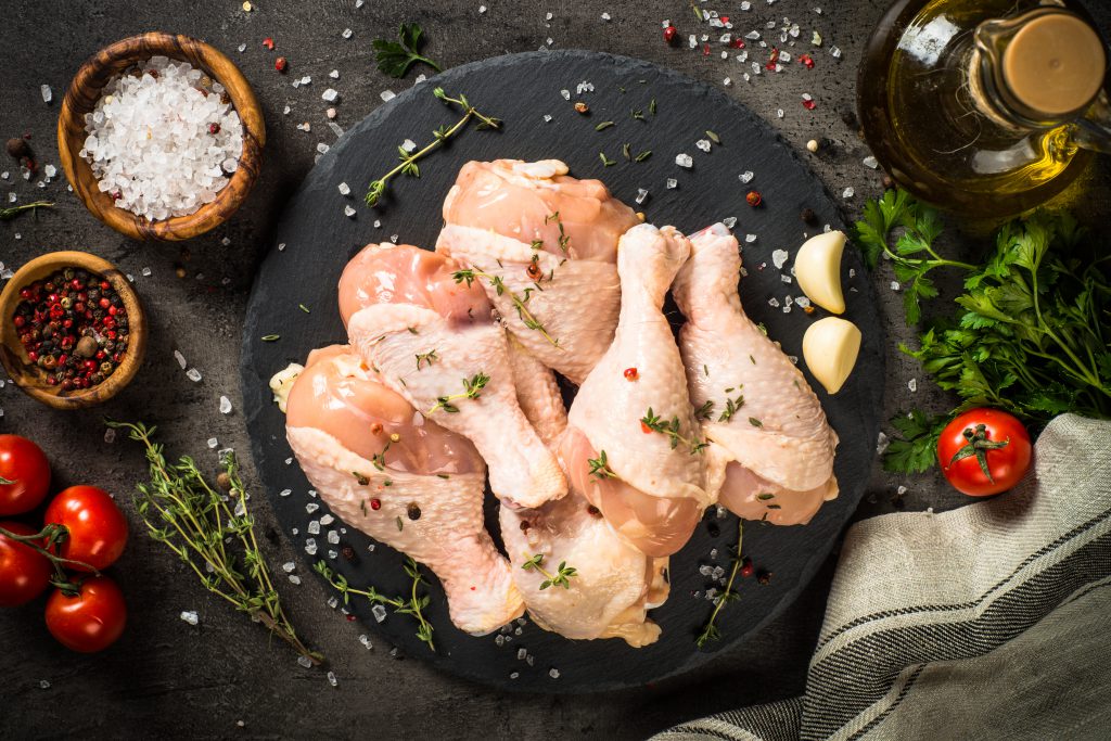 Chicken drumsticks with ingredients for cooking the best Kedjenou
